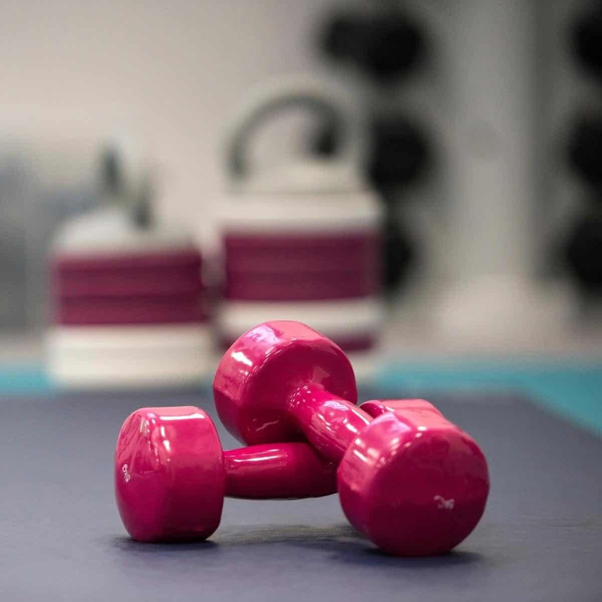 Pink Weights on a gym mat.
